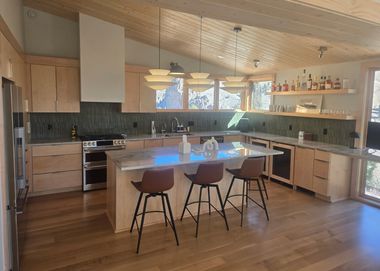 custom kitchen with gas range, marble island, and open bar shelving