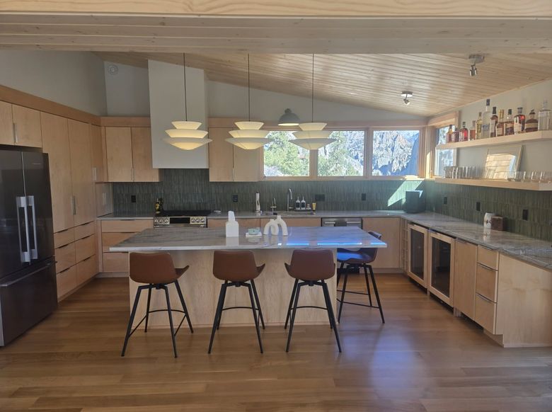 custom kitchen island with green tile backsplash and mountain view